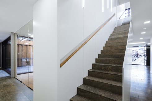 Die Treppe zu den Büros liegt geschützt im rück­wärtigen Teil des Empfangs.<br />