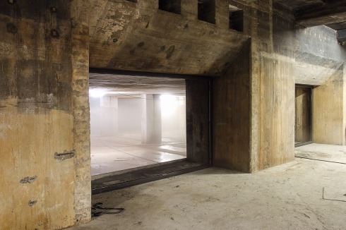 Vom Ausstellungsraum im Untergeschoss blickt man durch riesige Fenster in den gefluteten „Lake Room“.<br />
