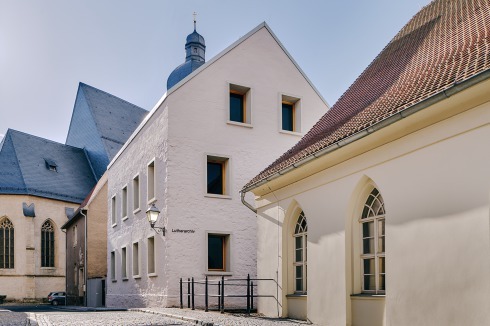 Dei drei Außenwände des Altbaus zu erhalten, kam dem Anliegen der Denkmalpflege, das Ensemble zu bewahren, entgegen. Vorn die ehemalige Armen­schule, hinten die Petrikirche.<br />