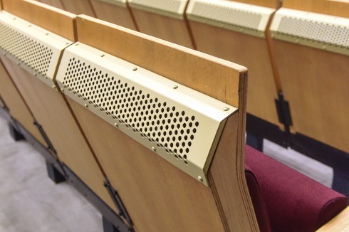 Die Stuhllehnen, jetzt mit neuen Verwirbelungsgit­tern. Die Luft wird aus einer unter dem Parkett angeordneten Druckkammer geblasen. Eine zweite, unter dem Rang geplante Druckkammer entpuppte sich als gar nicht ausgeführt.<br />