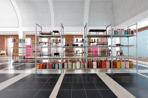Schwerlastregale mit Dosen voller Farbpigmente, Möbelentwürfen und Materialproben – Blick in die <br />Ausstellung im Erdgeschoss des DAM.<span class="OffWhite"></span><br />