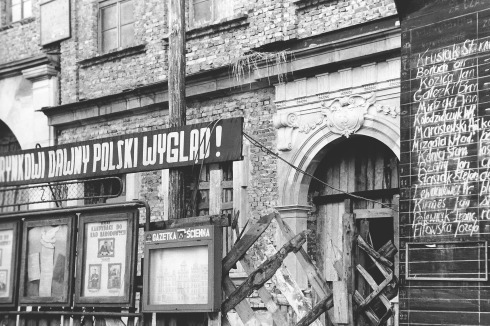 Oben: „Wir geben dem Ring sein früheres polnisches Aussehen zurück!“, hieß die offizielle Leitlinie zum Wiederaufbau des kriegszerstörten Rings. Schriftzug vor der bereits abgeputzten Fassade eines Bürgerhauses, 1955.<span class="OffWhite"></span><br />