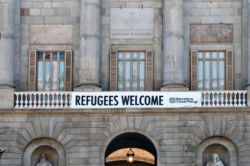 Inmitten der von Touristen bevölkerten Altstadt macht ein Banner am Rathaus die Haltung der Stadt Barcelona deutlich.<br />