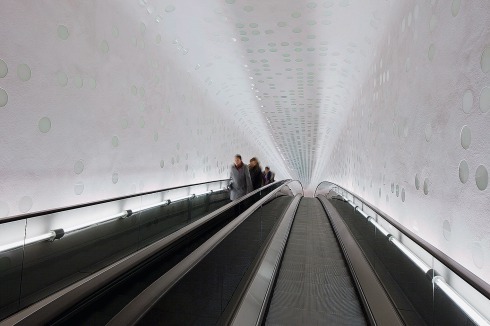 Die 82 m langen Rolltreppen ändern ihre Neigung. Sie überwinden bei einer Fahrtdauer von 2,5 Minuten 21,5 m Höhenunterschied. 8000 Glänzende Glaspunkte im matten Putz sorgen in der „Tube“ für Licht­effekte. Beim Konzert fahren beide Rolltreppen in die gleiche Richtung.<span class="OffWhite"></span><br />