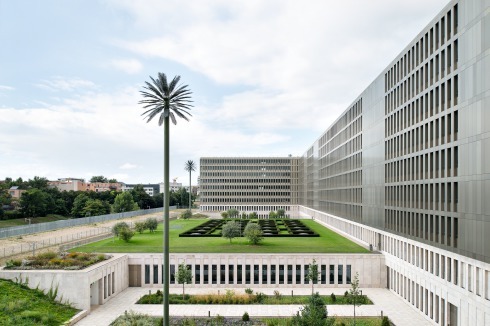 Die Rückseite. An den geschlossenen Fassadenteilen sind Erweiterungsbauten möglich. Die Palmen sind Kunst am Bau von Ulrich Brüschke.<span class="OffWhite"></span><br />