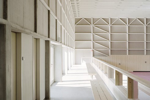 Die im Erdgeschoss in Beton ausgeführte Südwand dient der Aussteifung der Halle – konstruktiv wie ästhetisch.<br />