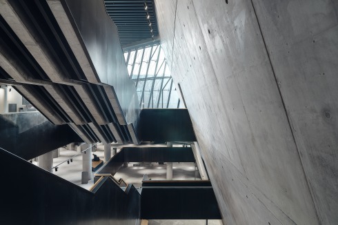 Das Hauptgebäude wird auch innen durch schräge Betonwände bestimmt. Die große Treppe hinunter zur Ausstellung ist sehr markant gestaltet. Handläufe und Eingänge sind in Holz ausgeführt.<br />