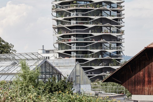 Die amorphe Form, die begrünte Fassade und die großzü­gigen Balkone brechen mit der bekannten Typologie.<br />