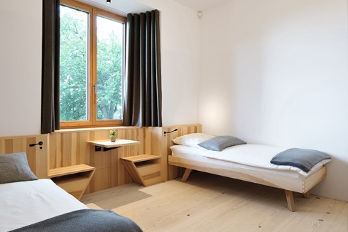 Die Gästezimmer vom Langen Haus im Erdgeschoss. Sie wurden mit Einbau­möbeln und Wandverkleidung aus Esche gestaltet.<br />