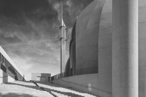Die großzügige Freitreppe führt hinauf zum Platz, an dessen Kopfende die Bibliothek steht. Die Holzkon­struktion der Laubengänge (links) erinnert an Masch­rabiyya, dekorative Holzgitter in der traditionellen islamischen Architektur.<br />
