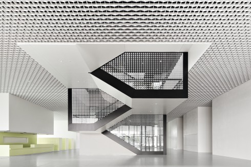 Im Foyer hebt sich die of­fene Treppe zur Ausstel­lungshalle im 1. OG hervor. Infotresen und Garderobe zeigen sich in mattem Grün.<br />