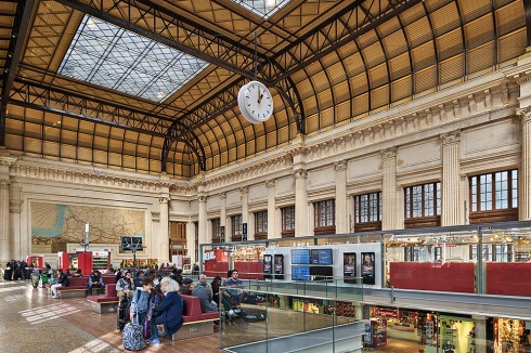Die alte Bahnhofshalle wurde in den letzten Jahren saniert und erhielt neue Sitzmöbel. Auf der tieferen Ebene gelangt man zur Passage unter den Bahngleisen, die auch zum Neubau führt.<br />