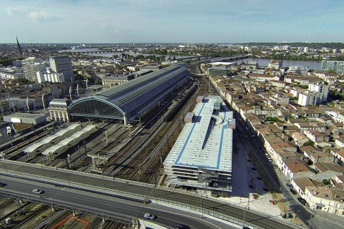 Der Bahnhof südöstlich des Stadtzentrums erhielt gegenüber den Gleisen eine weitere Halle. Der Neubau grenzt an ein altes, mit kleinen Häusern dicht bebautes Stadtquartier.<br />