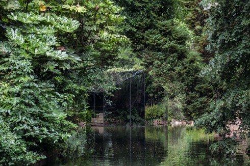 Halb Natur, halb Gebäude: Durch die Spiegelungen im Glas scheint der Pavillon im Dickicht des Ufers zu verschwinden.<br />