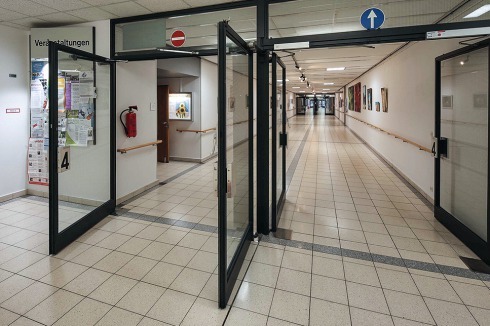 West-Eingangshalle mit großer Verglasung und der lange Flur im Flachbau.<br />
