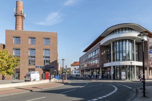 ... nördlich das neue Einkaufszentrum. Außer der Paschenhalle östlich des Bachlaufs „Kupfer­strang“ und dem Bürogebäude kündet der Schornstein von der indus­triellen Geschichte.<br />