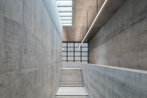 Die zentrale Treppe ver­bindet das Untere Foyer, die Zwischenebene und das Obere Foyer miteinander. Im Hintergrund der Infopoint mit der Abschlusswand aus Glas und Marmor von der griechischen Insel Thassos.<br />