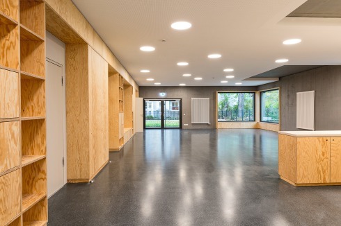Hölzerne Sitzflächen in den Fensternischen laden ein, den Beton zu bewohnen.<br />