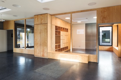 Eingangsfoyer und Spielzimmer sind durch eine Fenster in der Schrankwand verknüpft.<br />