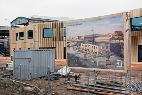 Bis zur Fertigstellung des Quartiers wurde auf der Baustelle ein Holzgebäude mit Flächen für Coworking-Plätze, Ausstellungs- und Gemeinschaftsräumen temporär platziert.<br />
