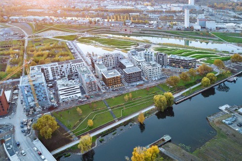 Blick Richtung Südwesten über das Buga-Gelände. Im Vordergrund der Neckar, im Hintergrund der Kanal­hafen, der weiterhin indus­triell genutzt wird, weshalb nach dort ein begehbarer Lärmschutzwall ausgebildet wurde.<br />