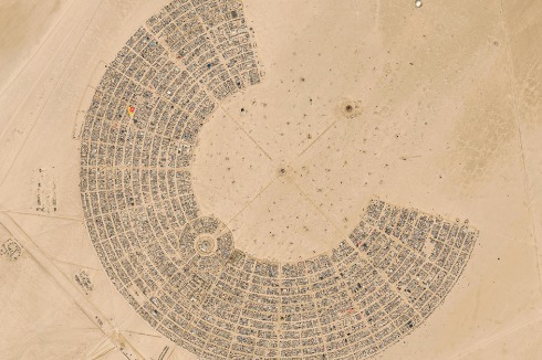 Festivalgelände mit Burning Man im Zentrum. Ein umlaufender „Trash Fence“ fängt Müll und Teilnehmer ab, bevor sich diese in die Wüste verlieren.<br />