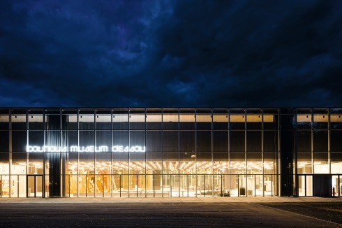 Bei nächtlicher Beleuchtung beginnt man das ursprüngliche Konzept zu ahnen: Das Ausstellungsgeschoss scheint über der riesigen Eingangshalle zu schweben.<br />