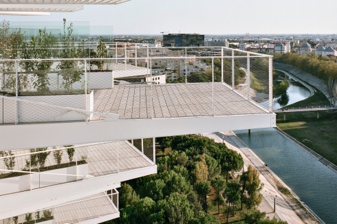 L’arbre Blanc steht in Sichtbezug zu Jean Nouvels Rathaus von 2011, einem schwarzen Block. Am Horizont dahinter schimmert ein Streifen Mittelmeer.<br />