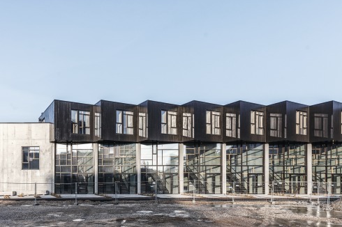 Ein Mosaik aus wiederverwendeten Holzrahmen prägt die Glasfront an der Südseite.<br />