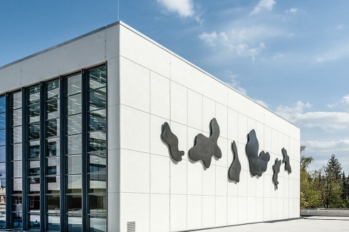 Der Kubus mit Wolkeninstallation und Aluminium-Glas-Fassade.<br />
