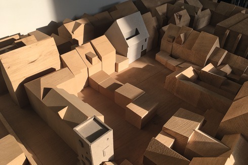 Das Modell zeigt links das Spitzdach von Zumthor und unten den geplanten Turm über der Einfahrt in den Hof der Drucke­rei von den Architekten Atelier ST.