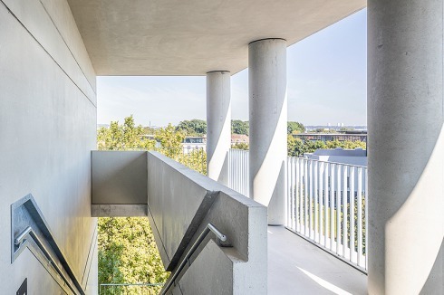 Die Treppenhäuser liegen, längs angeordnet, in den Ecken des Grundrisses, vor den 3- und 4-Zimmer-Wohnungen. Die scharfkantige Ausführung der Betonkanten kostete Geld, das an anderer Stelle eingespart werden musste – so entfiel etwa die geplante Pigmentierung des Betons.<br />