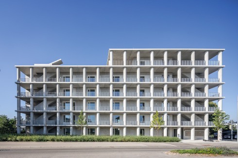 Das Betonhaus wirkt an der lauten Einfallstraße mit ihren gewerblichen Flachbauten wie ein Auftakt des städtischen Maßstabs.<br />