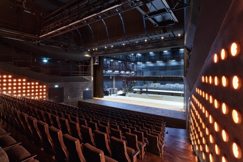 Der Große Saal bietet Platz für 600 bis 800 Zuschauer, abhängig davon, ob die vorderen Sitzreihen dem <br />Orchestergraben weichen müssen. Die vom Theater zur För­derung der Konzentration gewünschte Ausführung als „Black box“ haben die Architekten um Wandleuchten aus Blumentöpfen ergänzt.<br />