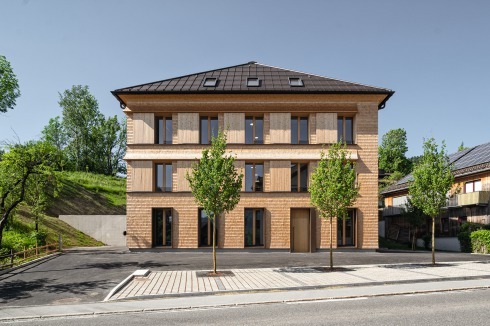 Die Holzverkleidung und das ausschwingende Gesims setzen Bezüge zur Bautradition der Gegend.<br />