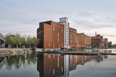 Die aus zwei Quadern und einem dreieckigen Volumen bestehende Erweiterung bildet den Schlusspunkt derHafen-Revitalisierung. Ein Abstandsgebot zur 40 Meter entfernten A59 ergab Platz für einen Park aus Bäumen.<br />