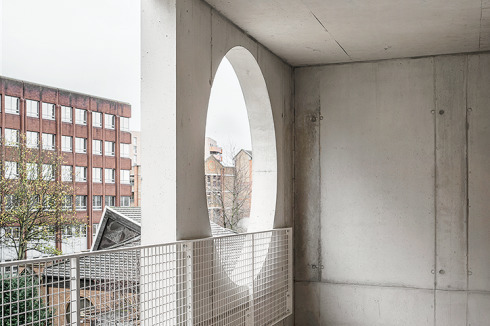 ... stehen die eingefügten geometrischen Formen in der Betonfassade entgegen und akzentuieren den Baukörper.<br />