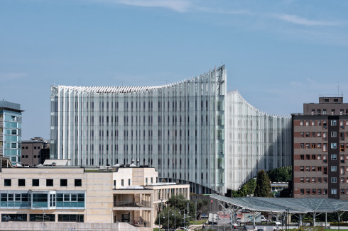 Über dem zurückhaltend gestalteten Podium baut sich ein siebengeschos­siger Turm mit extrovertierter Fassade auf.<br />