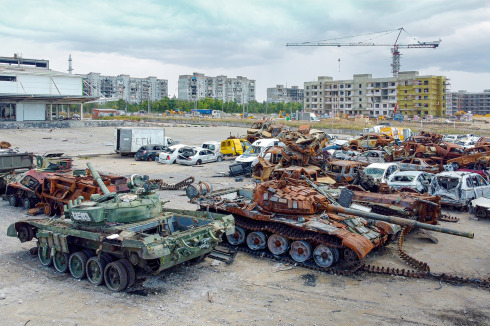Inszenierung für die internationale Presse: Auf einer Freifläche in Mariupol haben die russischen Besatzer Anfang August erbeutete Panzer und zivile Fahrzeuge gesammelt. Ein Lieferwagen trägt noch die Aufschrift „Kinder“. Die Kulisse ist nicht weniger zynisch. Neben Ruinen sollen eilig errichtete Wohnbauten eine neue Normalität suggieren.<br />
