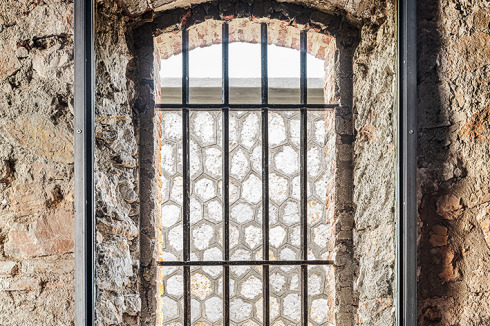Der Eingriff öffnet den Baukörper zur Stadt. Die alte Gefängnismauer ersetzen die Architekten durch einen mehrgliedrigen Portikus. Unter dem Dach aus transluszentem Kunststoff be­findet sich ein öffentlicher Speisesaal.<br />