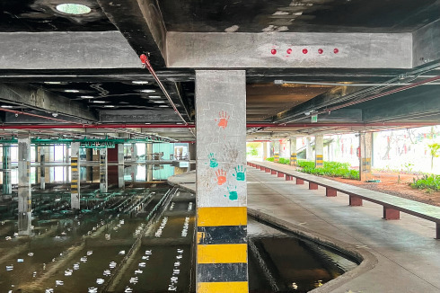 Markierungen von Untersuchungen der Konstruk­-tion und Handabdrücke von Angehörigen auf dem verrußten Beton der Parkgarage zeugen von der Geschichte des Ortes nach dem Brand.<br />