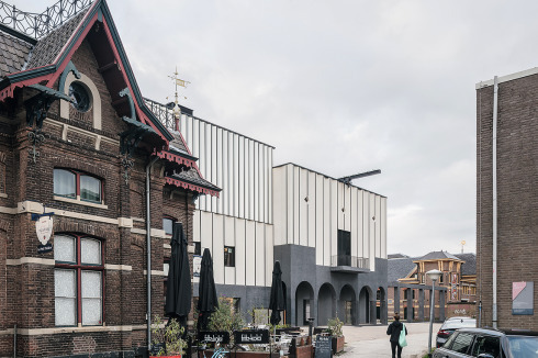 Die Probebühnen fügen sich zwischen den ebenfalls seit Jahren von Theatern genutzten Altbauten ein <br />(vorn links ein Theatercafé), die ursprünglich als Ver­waltungsbauten einer Gasfabrik dienten.<br />