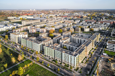 Für die HOWOGE planten blocher partners in Berlin-Adlershof das Quartier „Wohnen am Campus“ (Vordergrund) mit bogenförmig gestalteten Erdgeschossen, Gewerbe zur Parkseite und begrünten Höfen.<br />