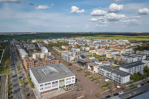 Platz an der Stadtbahn-Haltestelle mit Ärztehaus, Stadtteilzentrum, Einkaufsmöglichkeiten, Kirche und Pflegeheim.<br />
