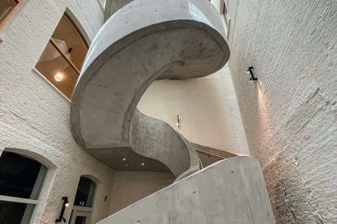 Die Spiral-Beton­treppe in einem kleinen Lichthof wurde aus Brandschutzgründen ergänzt.<br />