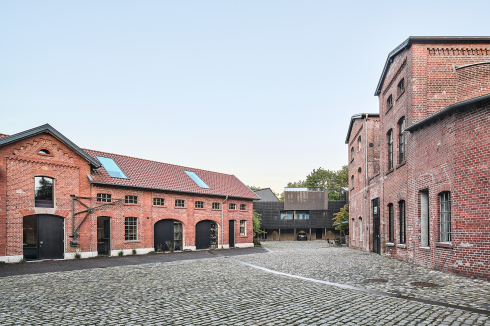 Der Platz zwischen Urbrennerei und Kellerei ist der Dreh- und Angelpunkt der verschiedenen, auf dem Brennereigelände angesiedelten Nutzungen. Die ehemaligen Kanäle für die Maische zeichnen sich als Bänder im Hof ab.<br />