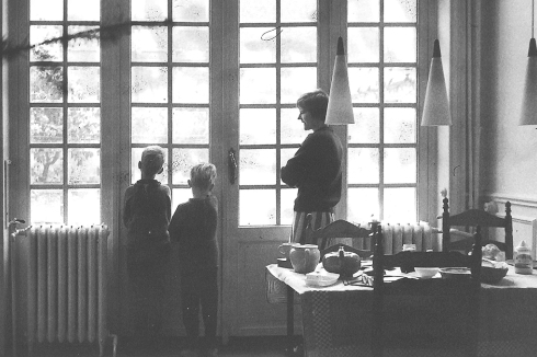 Autor des Beitrags mit äl-terem Bruder und Mutter 1965 vor der großen Fensterfont zum Garten. Das Haus von 1901 steht nahe der Abbaye de la Cambre im Stadtteil Ixelles. Die drei Wohnräume hintereinander waren sehr hoch, hatten aber nur eine Breite von ca. 5 Metern.<br />