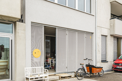 Der Eingangs­bereich fungiert als Vorplatz des Hauses. Das verstärkt die faltbare Streckmetall-Fassade, die sich über die gesamte Breite öffnen lässt.<br />