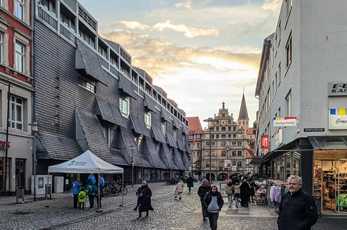 Musikschule und Konzertbereich sind separat erschlossen, die Zugänge verbinden sich. „Wie ein leichtes Kleid legt sich die Schieferfassade um das Gebäude, mal eng anliegend, mal wie durch einen Lufthauch bewegt, sanft gebogen und geöffnet“, kommentiert die Jury. Über die Entwässerung allerdings herrscht Schweigen.<br />