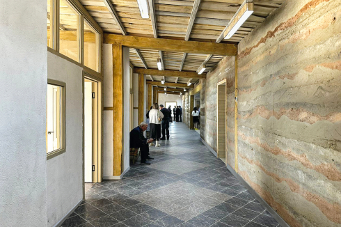 Die Räume sind auf her­ge­brachten Prinzipien entwickelt: Klassenräume reihen sich entlang eines Flurs. Besonderheit brin­gen Durchblicke und Oberlichter sowie eine durch­laufende Wand aus lokalem Stampf­lehm unterschied­licher Pigmentierung.<br />